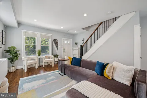 a living room with furniture and a dining table with garden view