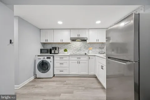 a kitchen with a refrigerator sink and cabinets