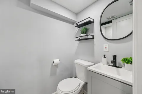 a bathroom with a toilet a sink and a mirror