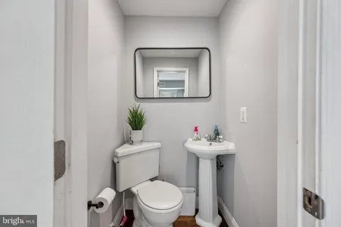 a bathroom with a sink mirror and toilet