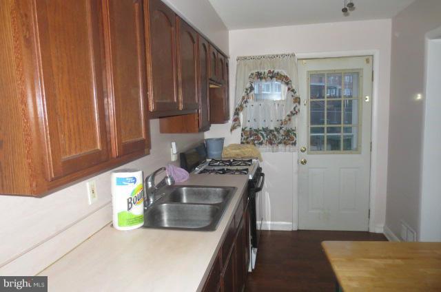 5506 Force Road Baltimore, MD 21206 - Photo 13 of 18 a kitchen with a stove and a wooden cabinets
