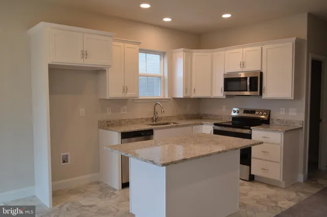 a kitchen with granite countertop cabinets stainless steel appliances and a sink