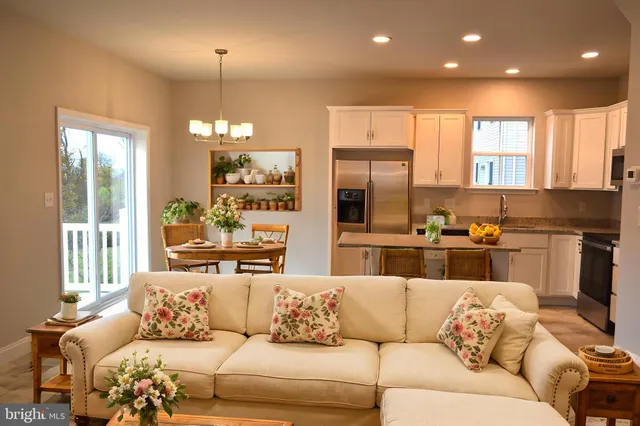 a living room with furniture kitchen and a large window