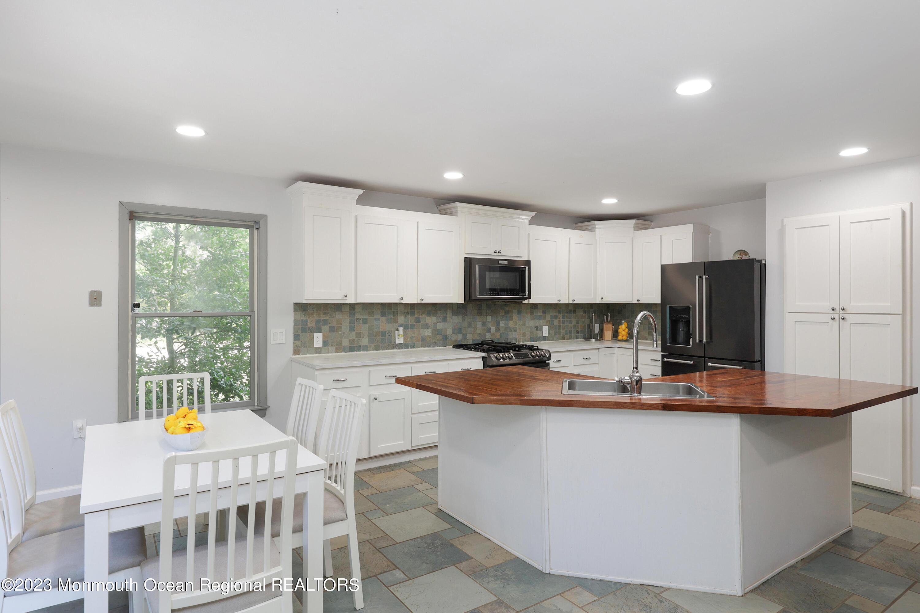 2450 Capshaw Road Forked River, NJ 08731 - Photo 11 of 37 a kitchen with stainless steel appliances granite countertop a sink a stove and a refrigerator