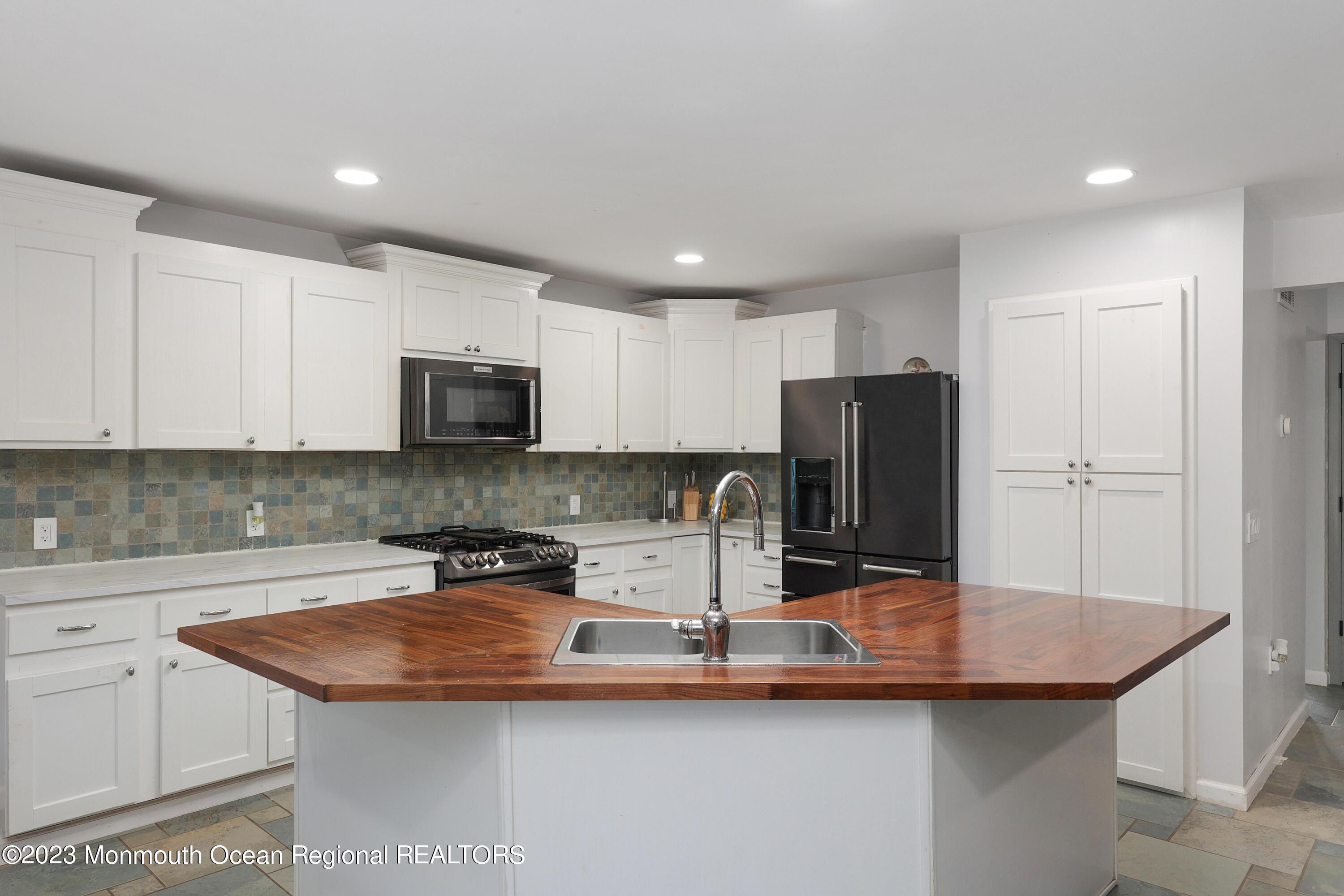 2450 Capshaw Road Forked River, NJ 08731 - Photo 12 of 37 a kitchen with stainless steel appliances granite countertop a sink a microwave and refrigerator