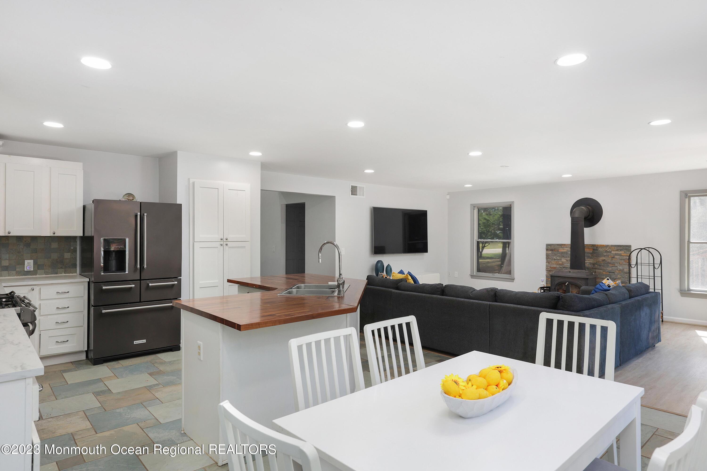 2450 Capshaw Road Forked River, NJ 08731 - Photo 14 of 37 a kitchen with stainless steel appliances kitchen island granite countertop a refrigerator a stove a microwave oven with a dining table and chairs