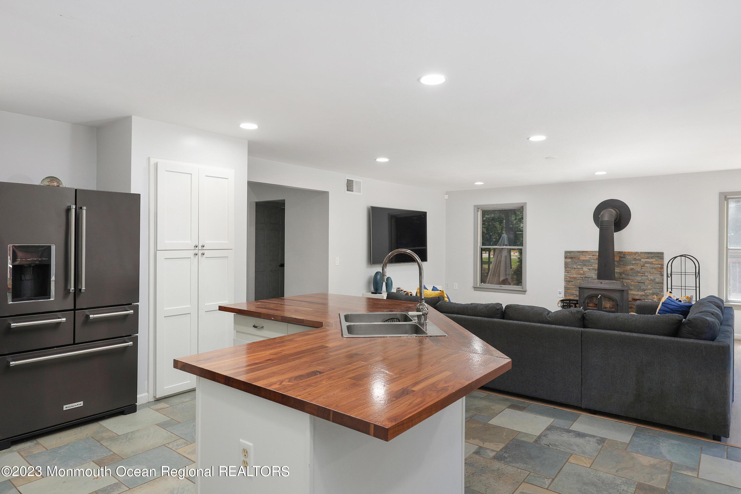 2450 Capshaw Road Forked River, NJ 08731 - Photo 15 of 37 a kitchen with stainless steel appliances kitchen island granite countertop a sink and a refrigerator