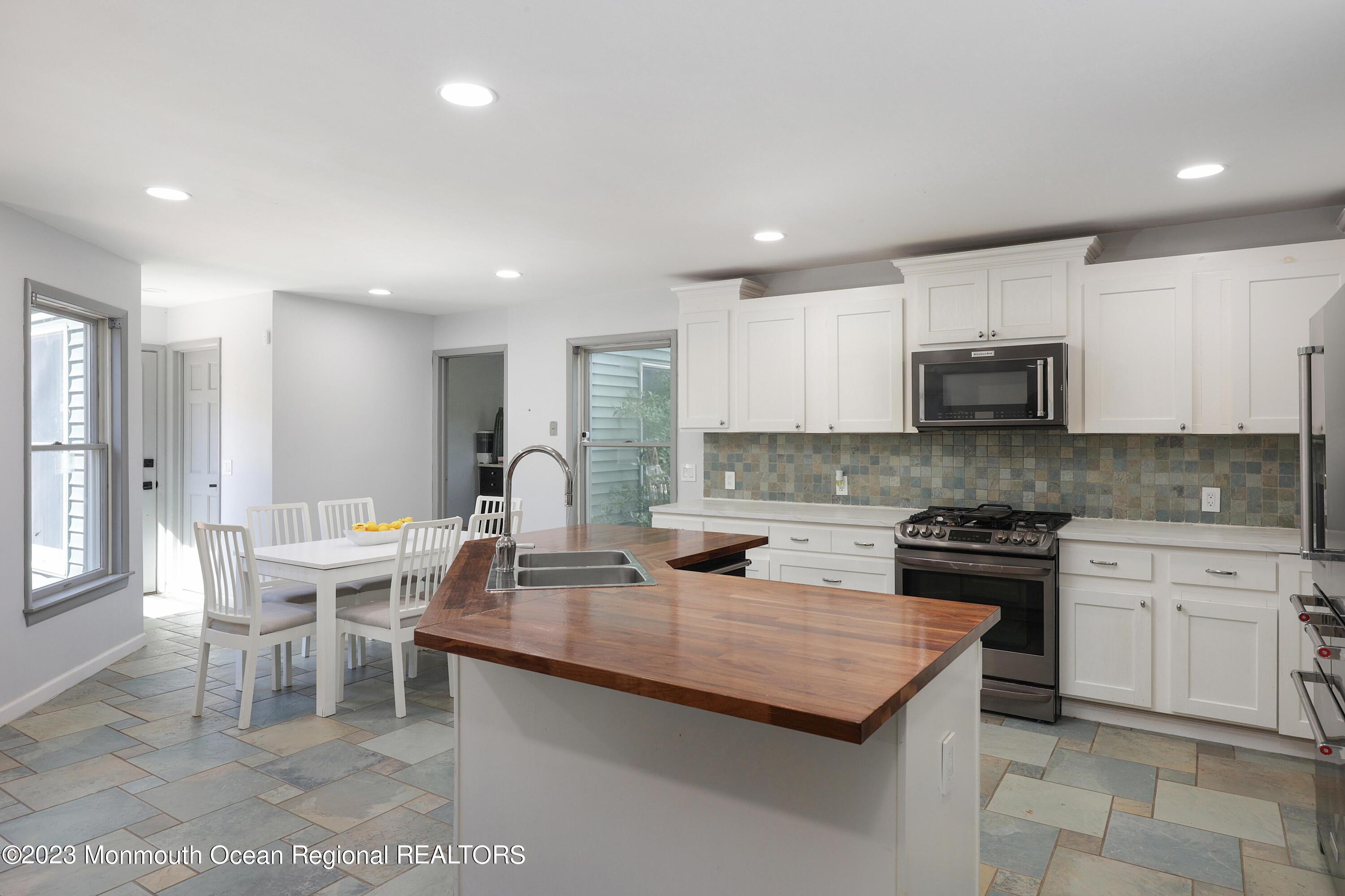 2450 Capshaw Road Forked River, NJ 08731 - Photo 17 of 37 a kitchen with a stove a sink a dining table and chairs