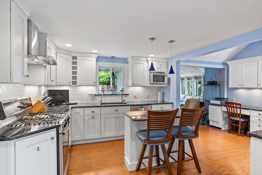 32 Melvin Road Arlington, MA 02474 - Photo 3 of 39 a kitchen with stainless steel appliances granite countertop a stove top oven a sink a dining table and chairs