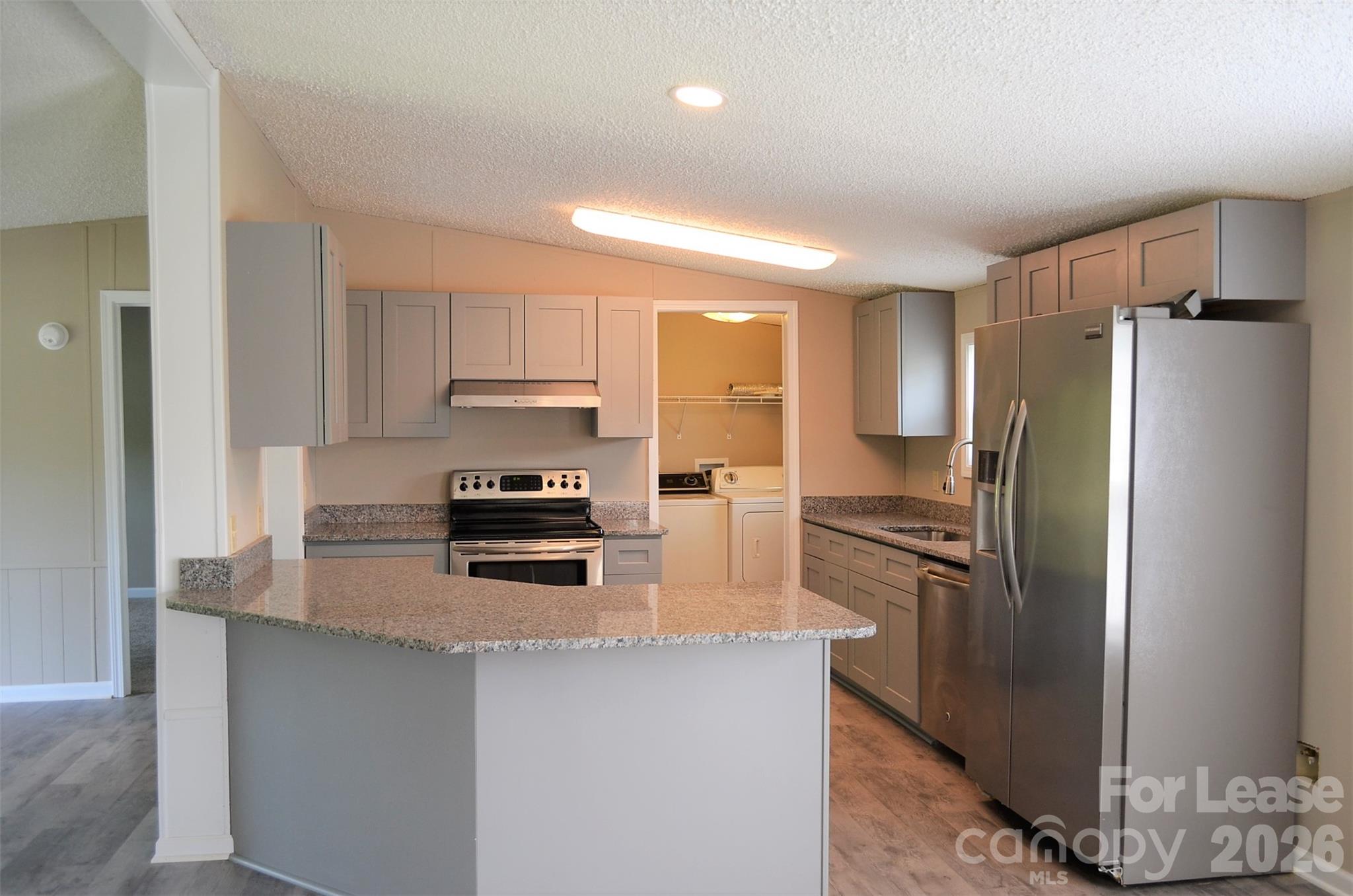 7167 Long Island Road Catawba, NC 28609 - Photo 18 of 34 a kitchen with granite countertop a refrigerator and a stove top oven