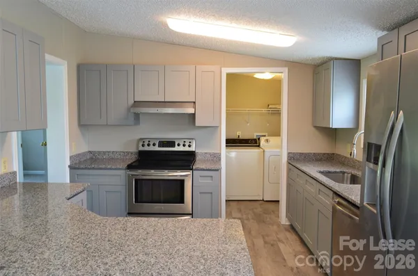 a kitchen with a stove a refrigerator and a sink