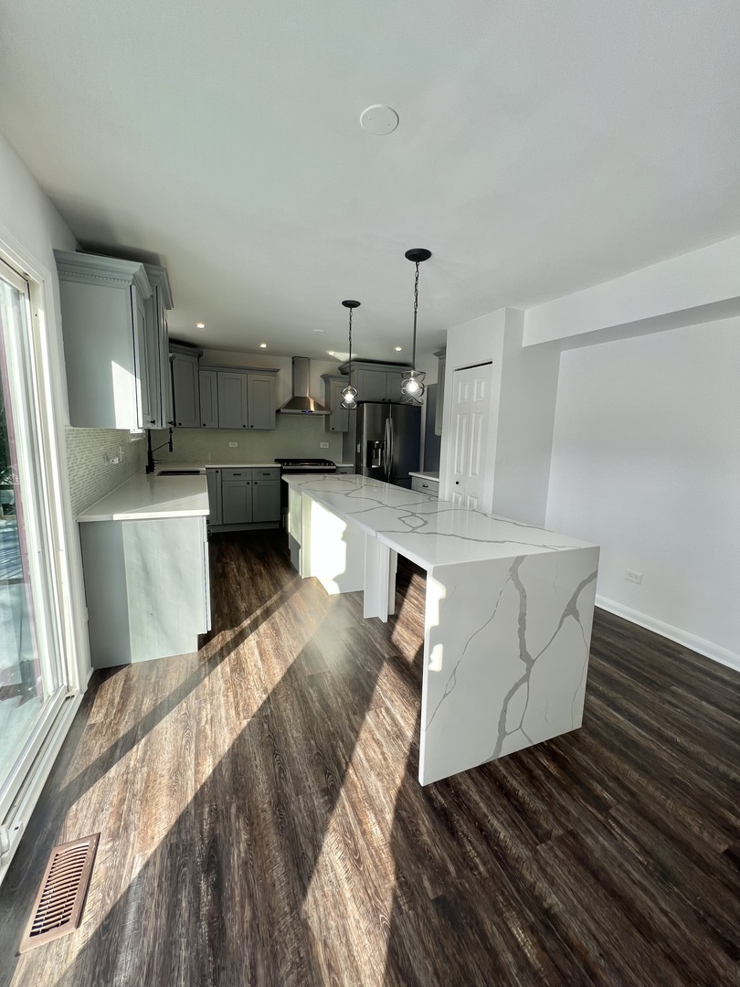 621 Buckboard Road Bolingbrook, IL 60490 - Photo 11 of 38 a living room with stainless steel appliances furniture a rug and a kitchen view