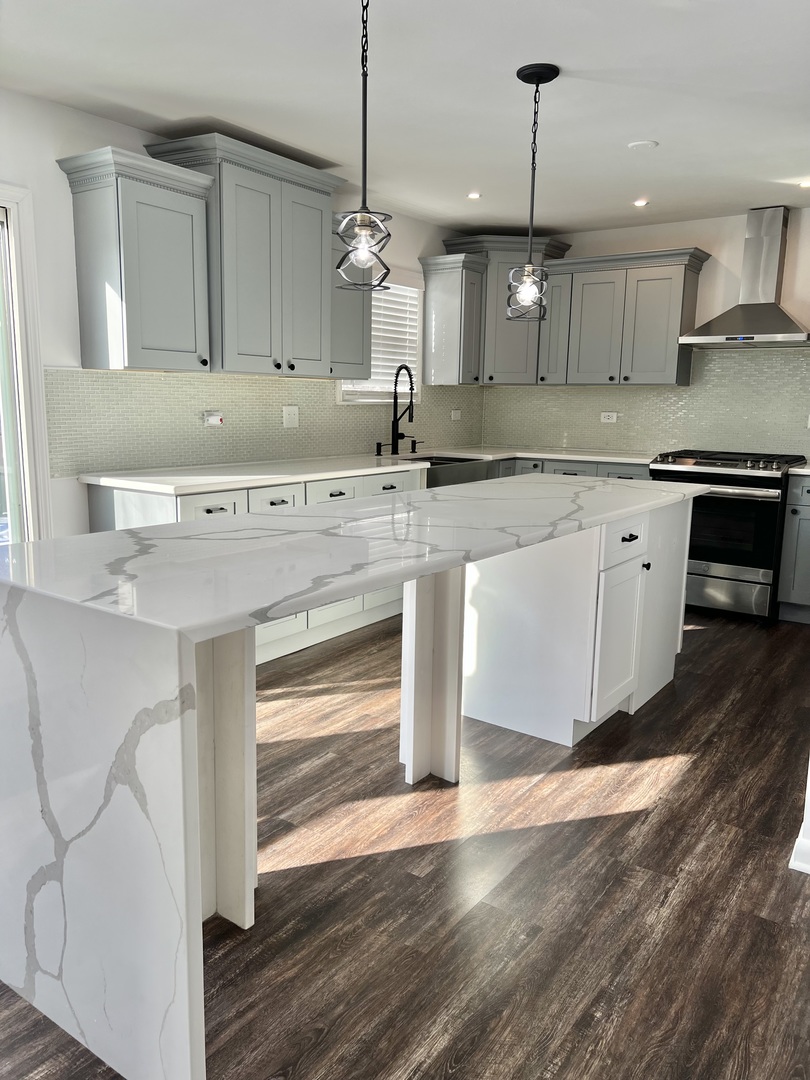 621 Buckboard Road Bolingbrook, IL 60490 - Photo 13 of 38 a large kitchen with stainless steel appliances kitchen island granite countertop a sink a counter space and wooden floor