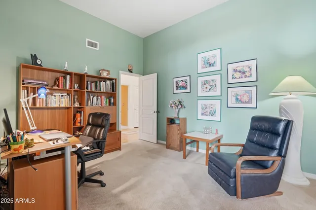 a bedroom with bed and paintings on the wall