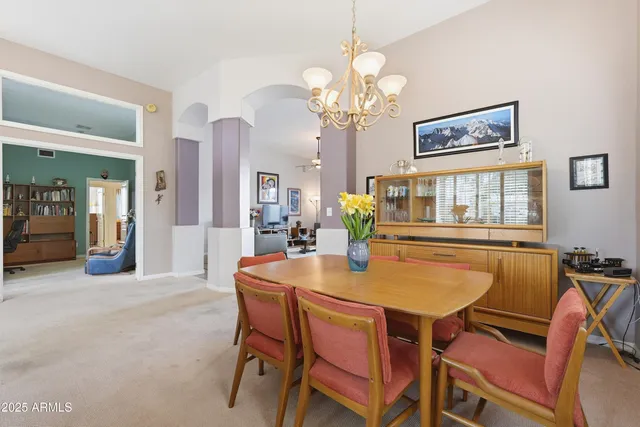 a kitchen with stainless steel appliances granite countertop a stove top oven a sink dishwasher a dining table and chairs with wooden floor