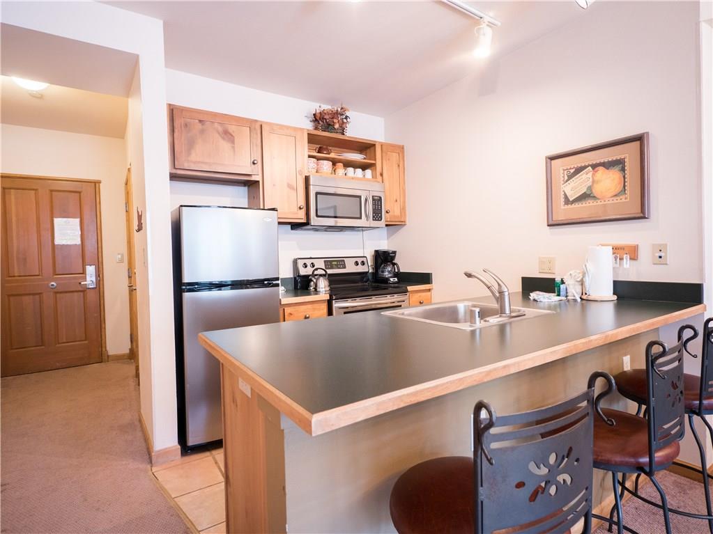 129 River Run Road, Unit 8064 Keystone, CO 80435 - Photo 5 of 21 a kitchen with stainless steel appliances granite countertop a sink a stove and a refrigerator