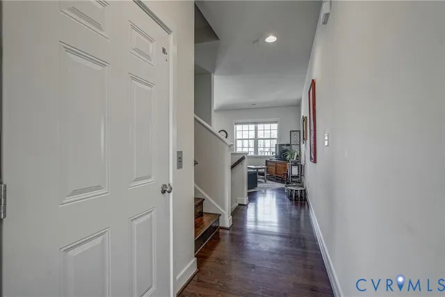 a view of hallway with wooden floor and furniture