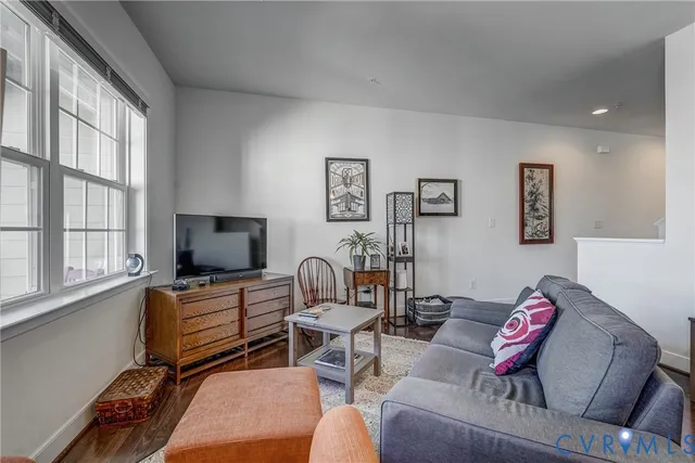 a living room with furniture a flat screen tv and a window