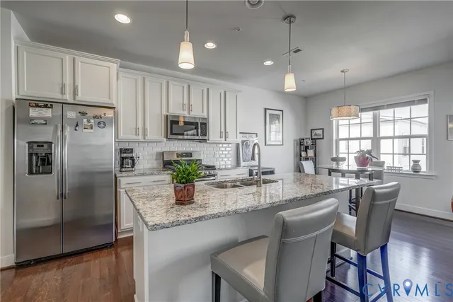 a kitchen with kitchen island granite countertop a center island a sink stainless steel appliances and cabinets