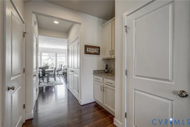a kitchen with white cabinets and wooden floor