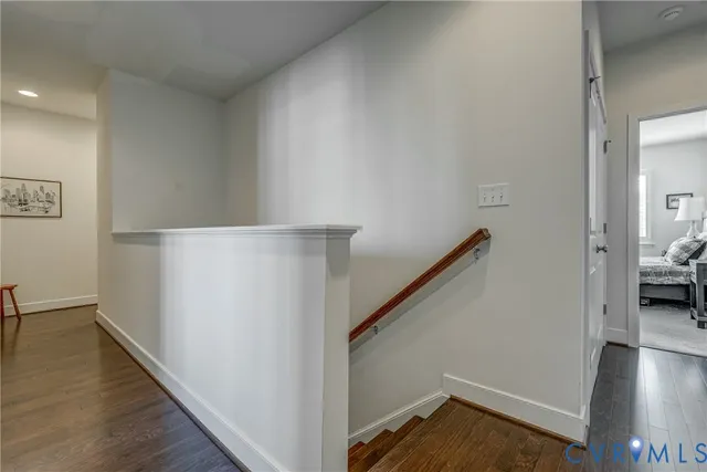 a view of a hallway with wooden floor and stairs