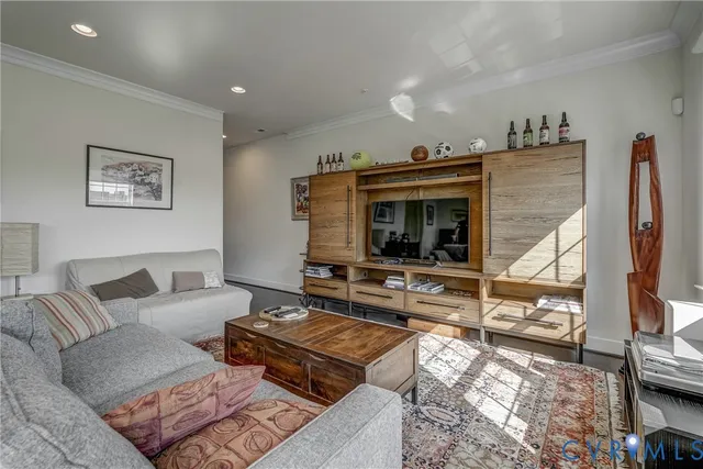 a living room with furniture a flat screen tv and a floor to ceiling window