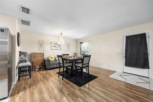 a view of a a dining room with furniture window and wooden floor