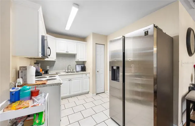 a kitchen with a refrigerator a sink and cabinets