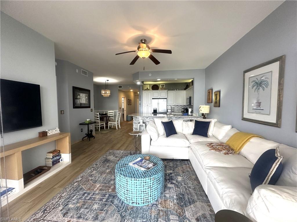 470 Launch Circle, Unit V503 Naples, FL 34108 - Photo 13 of 30 a living room with furniture a flat screen tv and kitchen view