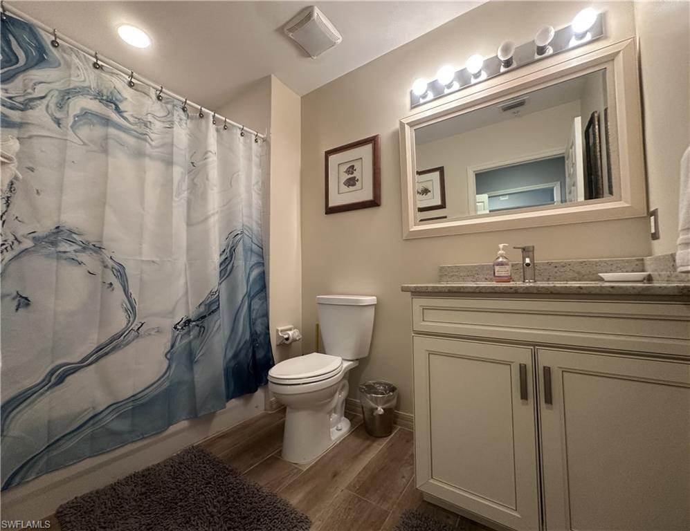 470 Launch Circle, Unit V503 Naples, FL 34108 - Photo 19 of 30 a bathroom with a granite countertop toilet sink and mirror