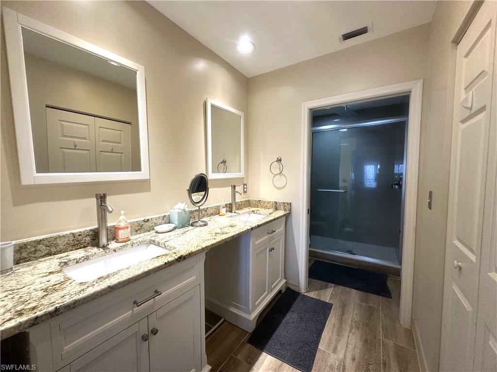 470 Launch Circle, Unit V503 Naples, FL 34108 - Photo 9 of 30 a bathroom with a sink a vanity and a mirror
