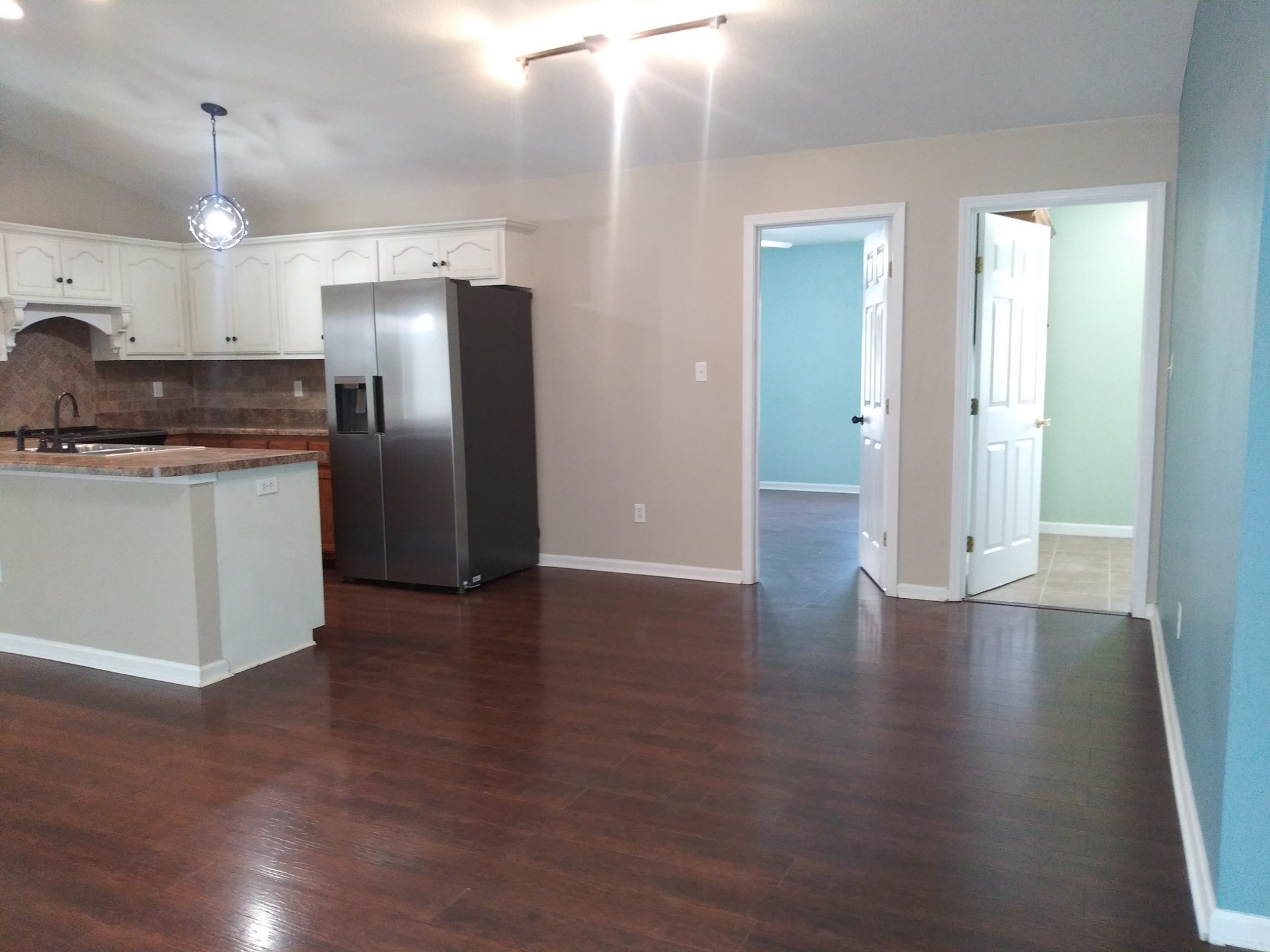 5330 Long Branch Road Tennessee Ridge, TN 37178 - Photo 29 of 57 an empty room with wooden floor kitchen view and windows