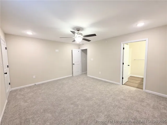 an empty room with a ceiling fan and a window