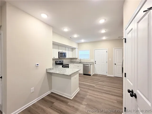 a kitchen with white cabinets and white appliances