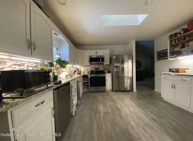 a kitchen with stainless steel appliances a stove top oven a sink dishwasher and a refrigerator