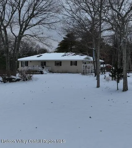 a view of a house with a yard covered in snow