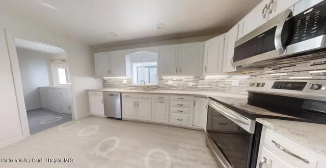 a kitchen with granite countertop a sink cabinets and stainless steel appliances