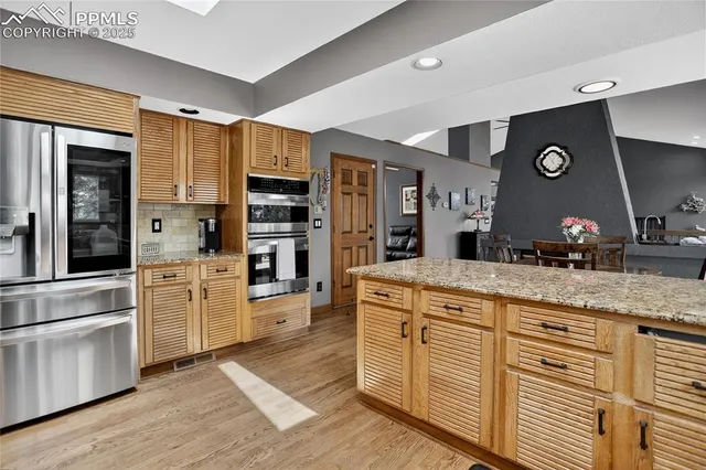 a kitchen with stainless steel appliances granite countertop a stove and cabinets