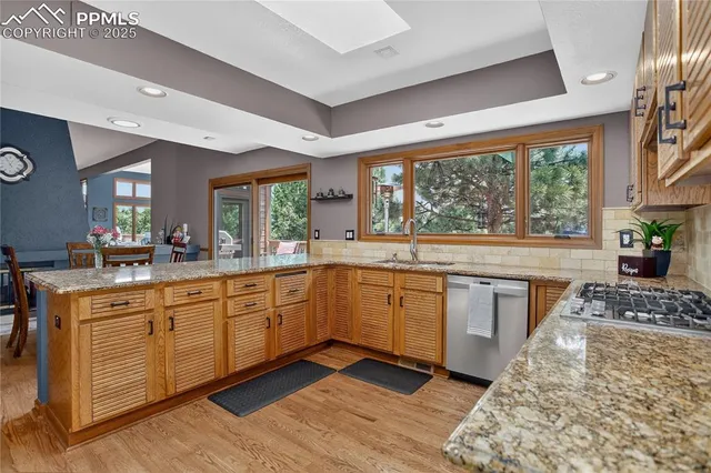 a kitchen with stainless steel appliances granite countertop a stove a sink and a refrigerator