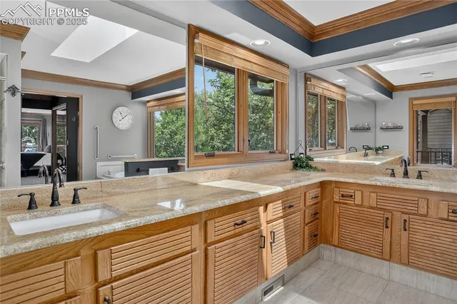 a view of a double vanity sink and mirror with large window