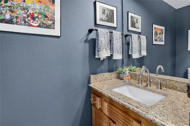 a bathroom with a granite countertop sink and a mirror