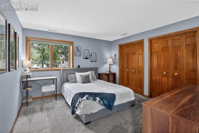 a bedroom with a bed and large windows