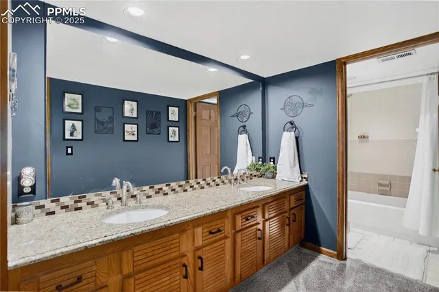 a spacious bathroom with a granite countertop sink and a mirror