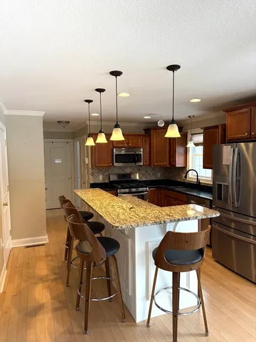 a kitchen with a table chairs refrigerator and microwave