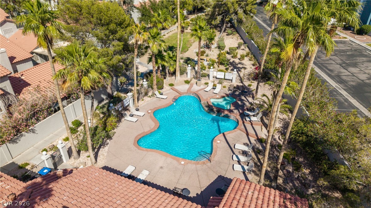 2223 Ramsgate Drive Henderson, NV 89074 - Photo 32 of 32 An inviting community pool and spa with ample lounging areas amidst lush palm trees.
