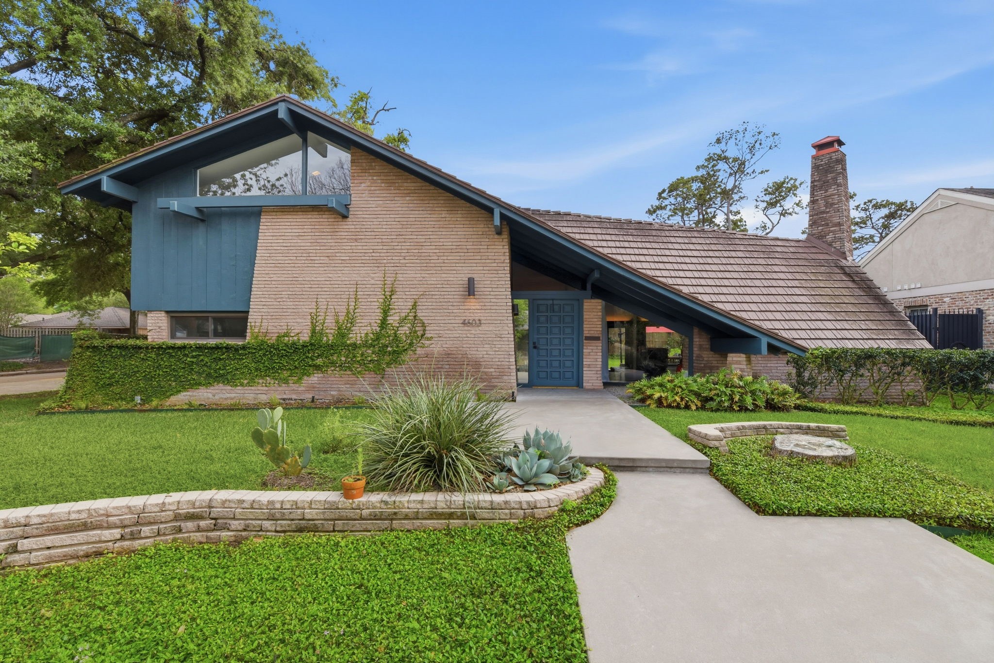 Striking mid-century modern facade with clean lines and mature landscaping.