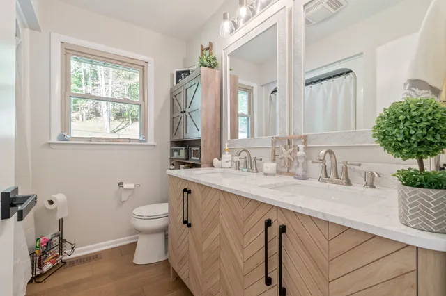 a bedroom with a bed and a flat tv screen on dresser