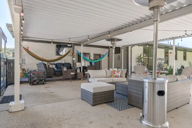 a view of a lake with a table and chairs in the patio