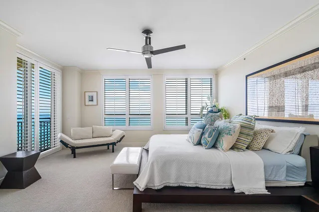 a bedroom with a bed couch and a potted plant
