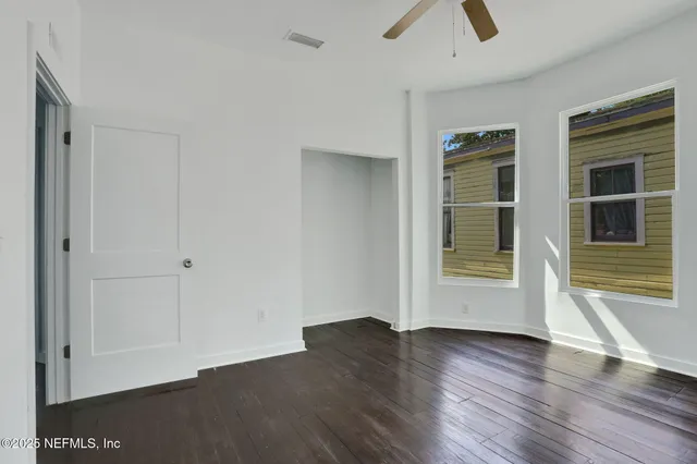 an empty room with wooden floor and window